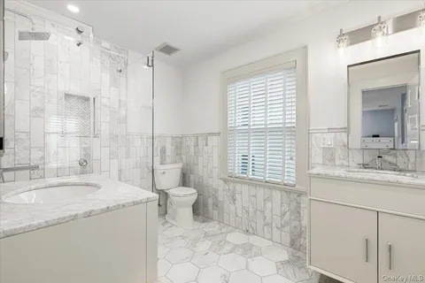 a bathroom with a granite countertop sink toilet and shower