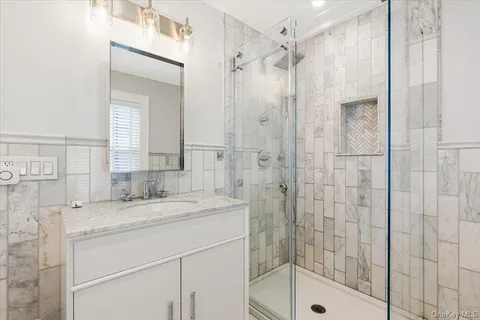 a bathroom with a shower sink and mirror