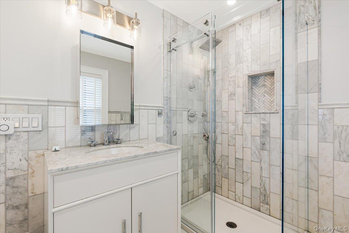 13 Harrison Street Tuckahoe, NY 10707 - Photo 30 of 44 a bathroom with a shower sink and mirror
