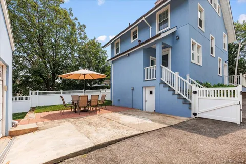 a backyard of a house with table and chairs