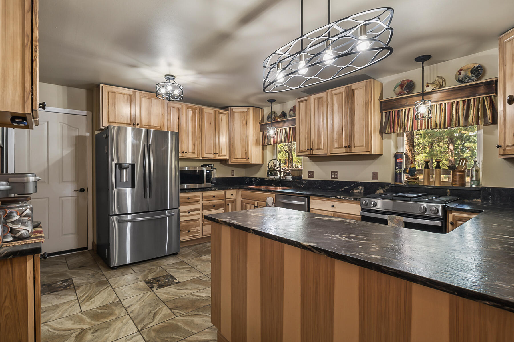 15730 Jackpine Road La Pine, OR 97739 - Photo 14 of 43 a kitchen with stainless steel appliances granite countertop a refrigerator a sink dishwasher a stove and a refrigerator with wooden floor