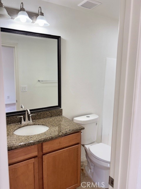23302 Marigold Avenue, Unit Y204 Torrance, CA 90502 - Photo 8 of 16 a bathroom with a granite countertop sink toilet and mirror