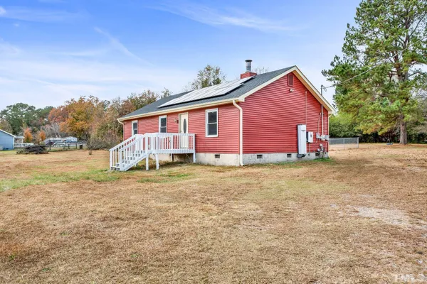 a view of a house with backyard and trees
