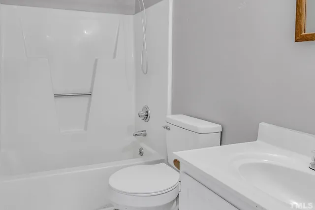 a white toilet sitting next to a bath tub