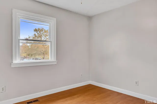 a room with a window and painting on the wall