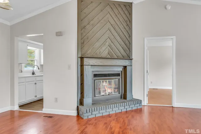 a view of a livingroom with wooden floor and a fireplace