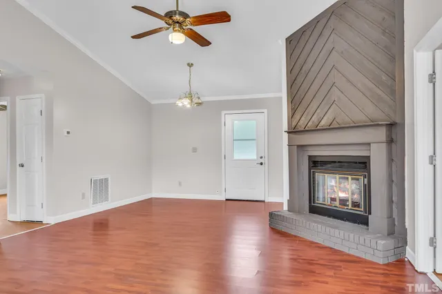 a view of empty room with wooden floor and fireplace