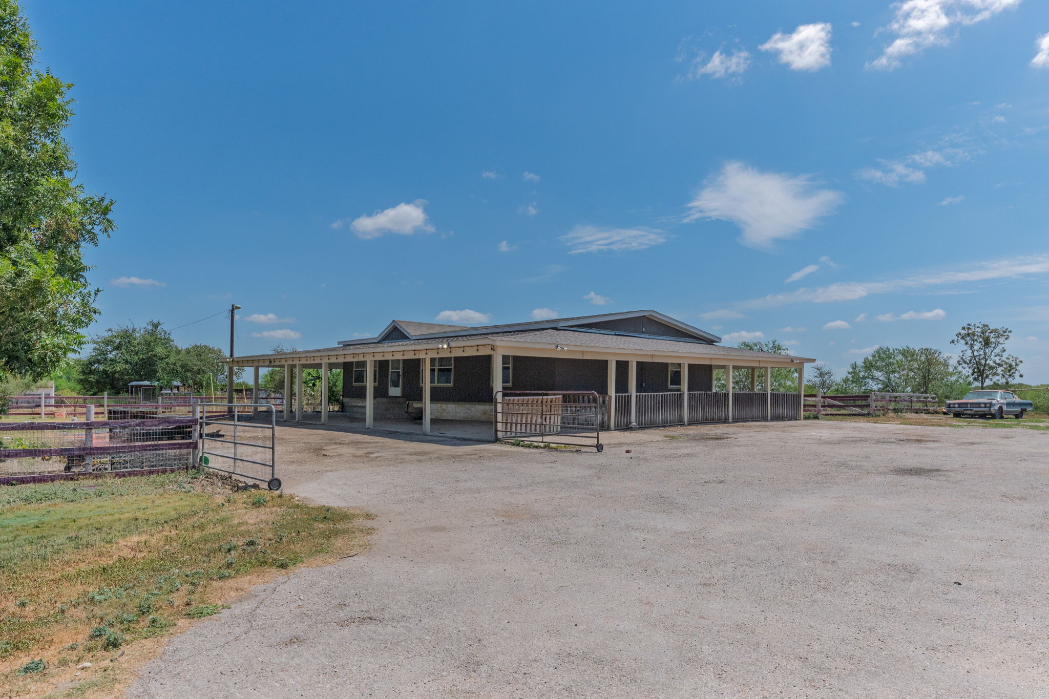 1781 Long Road Lockhart, TX 78644 - Photo 7 of 17 Shingle roofing and a spacious covered porch define this rural structure set on open acreage.