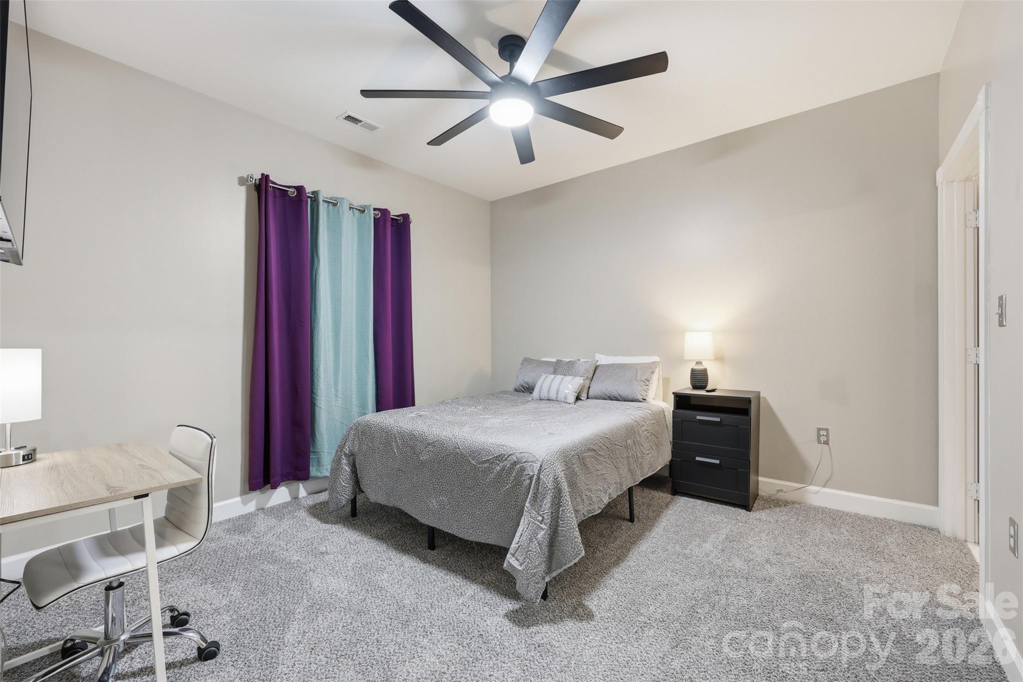 9054 Meadow Vista Road Charlotte, NC 28213 - Photo 18 of 30 a bedroom with a bed and a chandelier