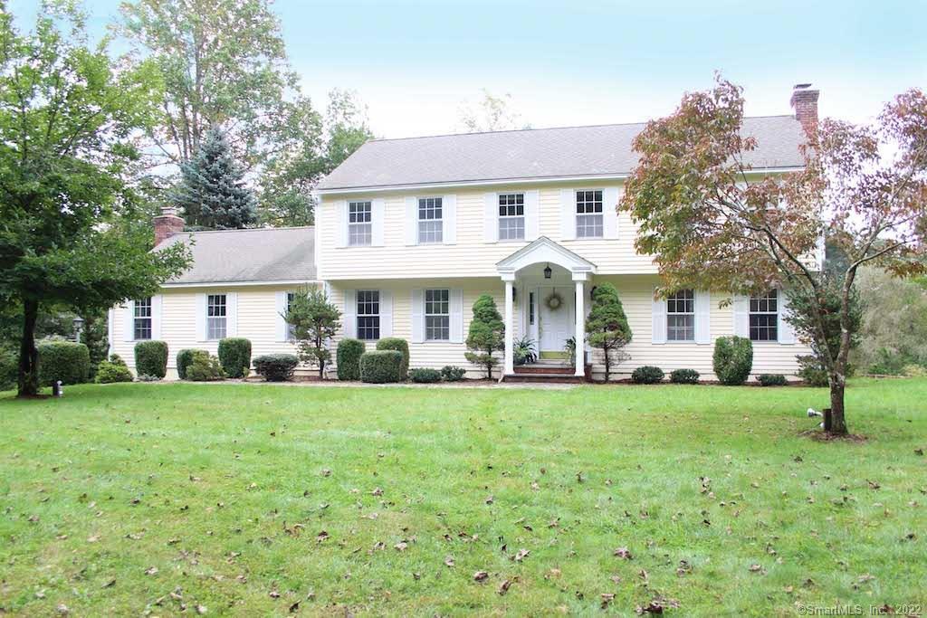 232 Thunder Lake Road Wilton, CT 06897 - Photo 1 of 1 a front view of a house with a garden and trees