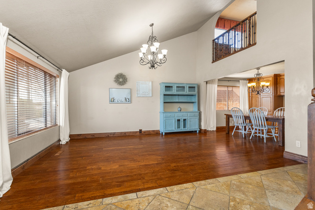892 Cambridge Drive St. George, UT 84770 - Photo 32 of 65 Vaulted ceiling great room featuring wood-finish flooring, a decorative chandelier, and a large window with blinds