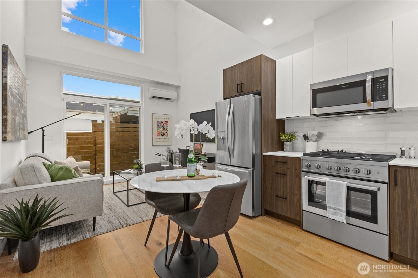 5439 California Avenue Southwest, Unit H Seattle, WA 98136 - Photo 2 of 23 a kitchen with stainless steel appliances a stove a sink dishwasher a refrigerator with a dining table and chairs