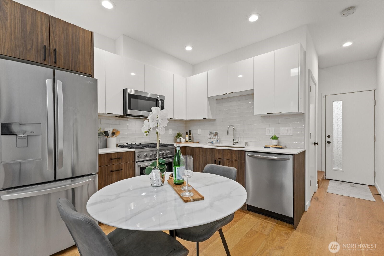 5439 California Avenue Southwest, Unit H Seattle, WA 98136 - Photo 7 of 23 a kitchen with stainless steel appliances granite countertop a sink a stove a refrigerator cabinets and a dining table