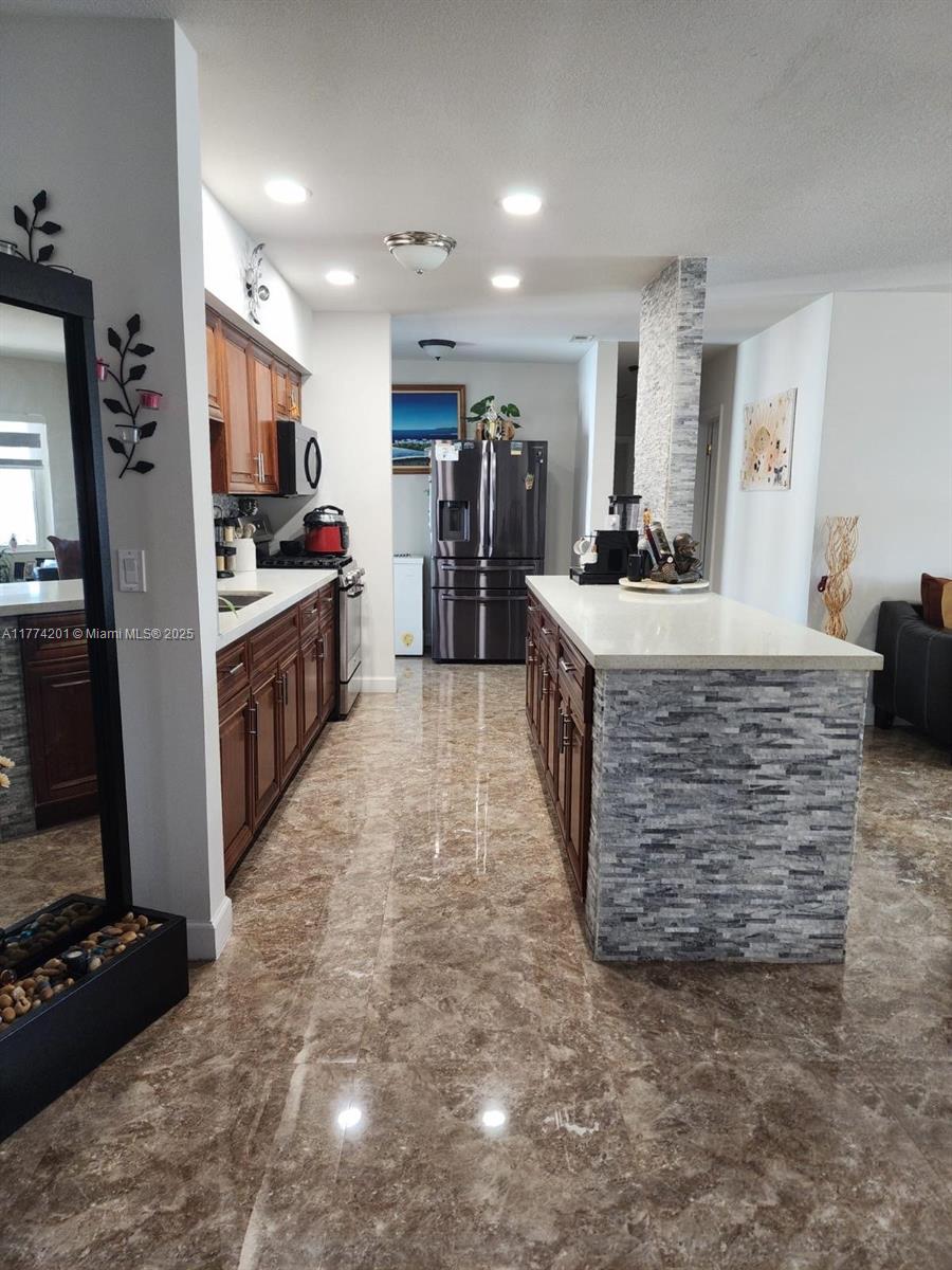 341 West 59th Street Hialeah, FL 33012 - Photo 12 of 44 a large kitchen with kitchen island sink stove and refrigerator