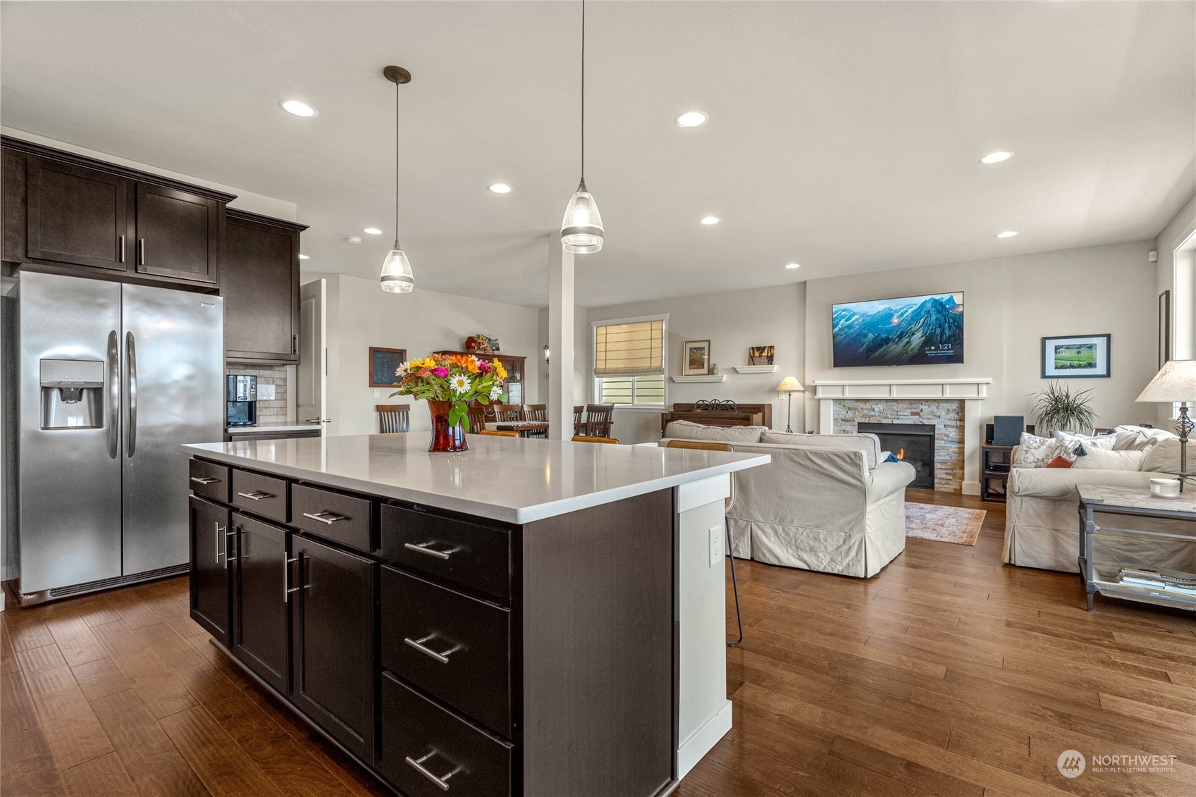 19012 123rd Avenue Southeast Renton, WA 98058 - Photo 14 of 40 a kitchen with stainless steel appliances granite countertop a sink dishwasher a refrigerator and a dining table with wooden floor