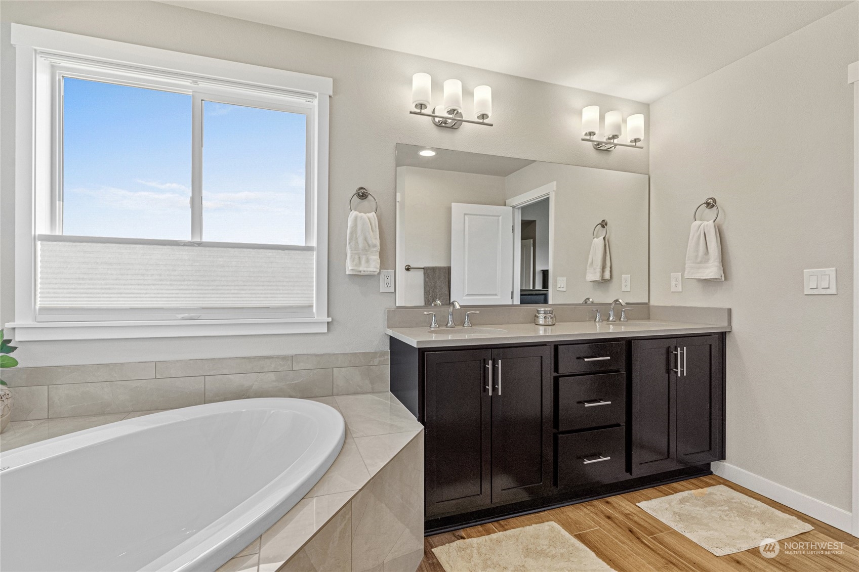 19012 123rd Avenue Southeast Renton, WA 98058 - Photo 20 of 40 a bathroom with a tub a double vanity sink and a mirror