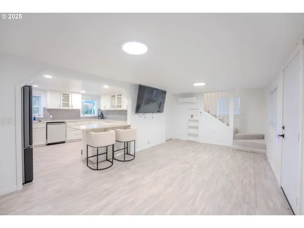 a room with a flat screen tv and white walls