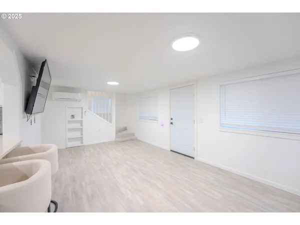 a view of an empty room with wooden floor