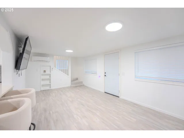 a view of an empty room with wooden floor