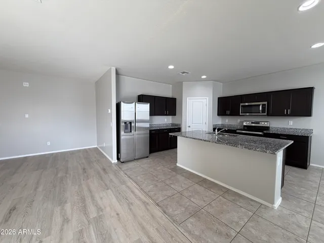 a large kitchen with kitchen island granite countertop a large counter top stainless steel appliances and cabinets