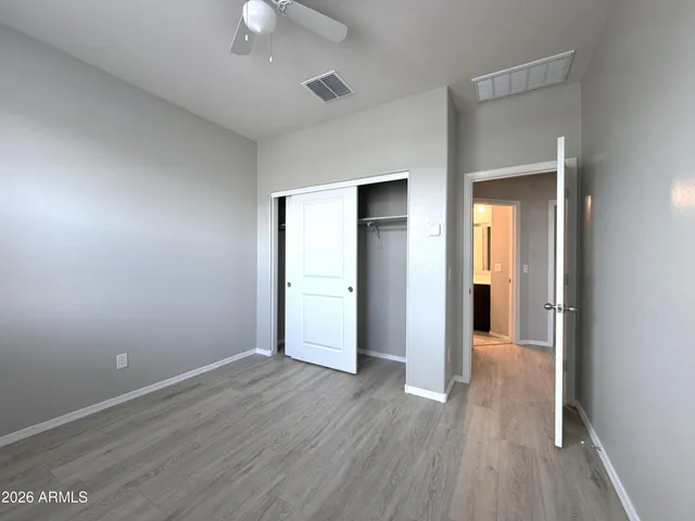 an empty room with wooden floor and closet