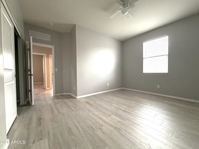 an empty room with window and wooden floor