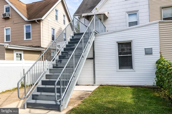 a view of a house with backyard and white walls