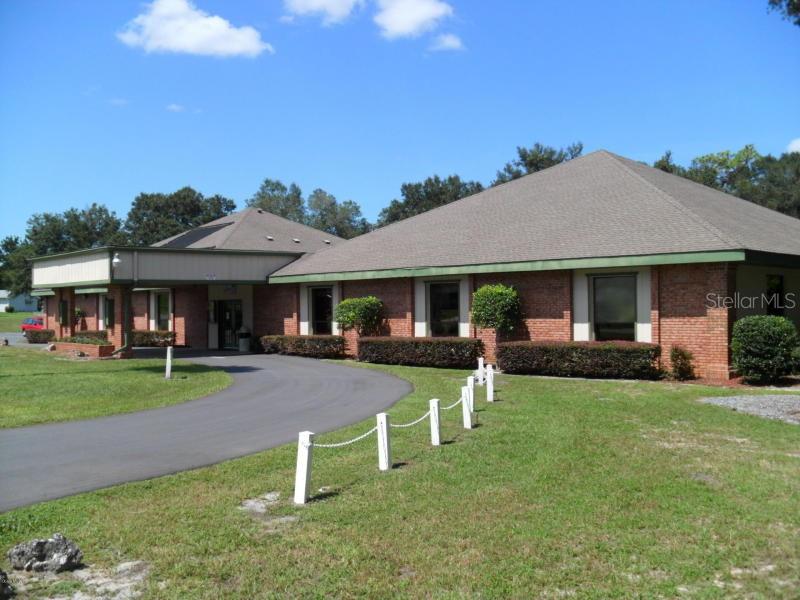 11087 Southwest 77th Court Ocala, FL 34476 - Photo 29 of 31 a patio with a table and chairs under an umbrella