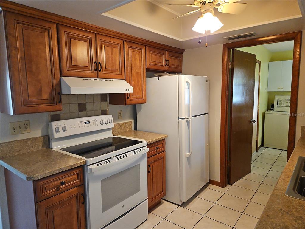 11087 Southwest 77th Court Ocala, FL 34476 - Photo 8 of 31 a kitchen with a stove refrigerator and cabinets