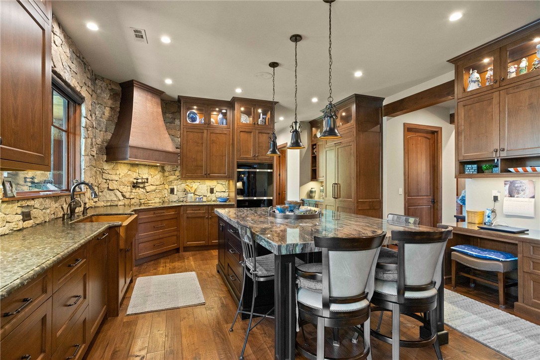 236 Palmer Way Sunset, SC 29685 - Photo 6 of 46 Gourmet kitchen boasts a custom range hood, stone accent wall, and a large central island with bar seating.