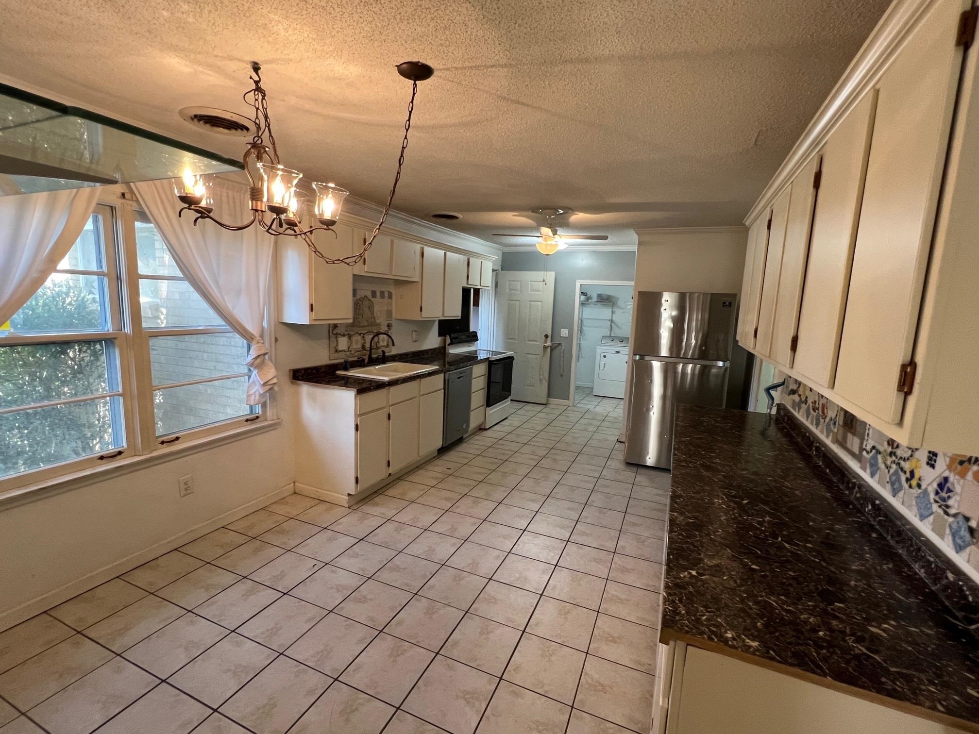 4356 Grey Road Memphis, TN 38108 - Photo 8 of 22 a large kitchen with granite countertop a stove a sink and a refrigerator