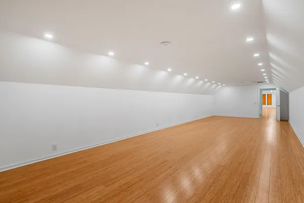 a view of empty room with wooden floor