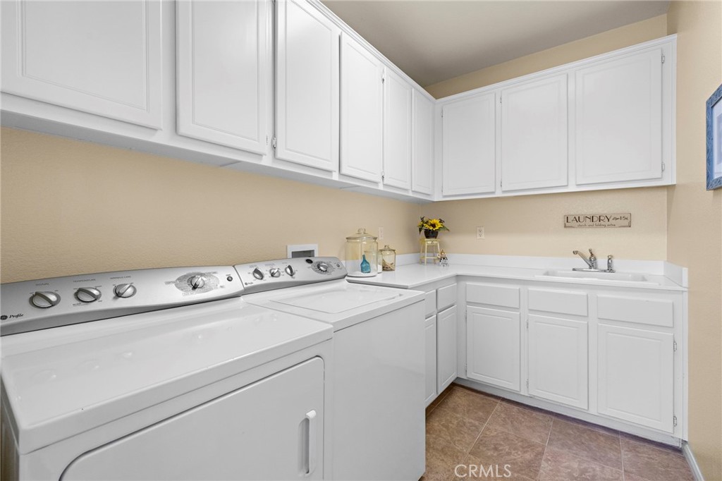 28545 Raintree Drive Menifee, CA 92584 - Photo 28 of 33 a utility room with cabinets washer and dryer