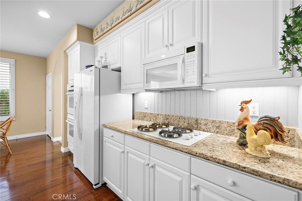 28545 Raintree Drive Menifee, CA 92584 - Photo 10 of 33 a kitchen with granite countertop white cabinets and a stove
