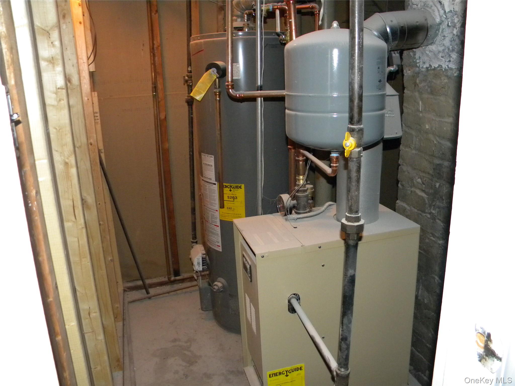 241-26 86th Road Queens, NY 11426 - Photo 30 of 38 a room with water heater and wooden cabinets