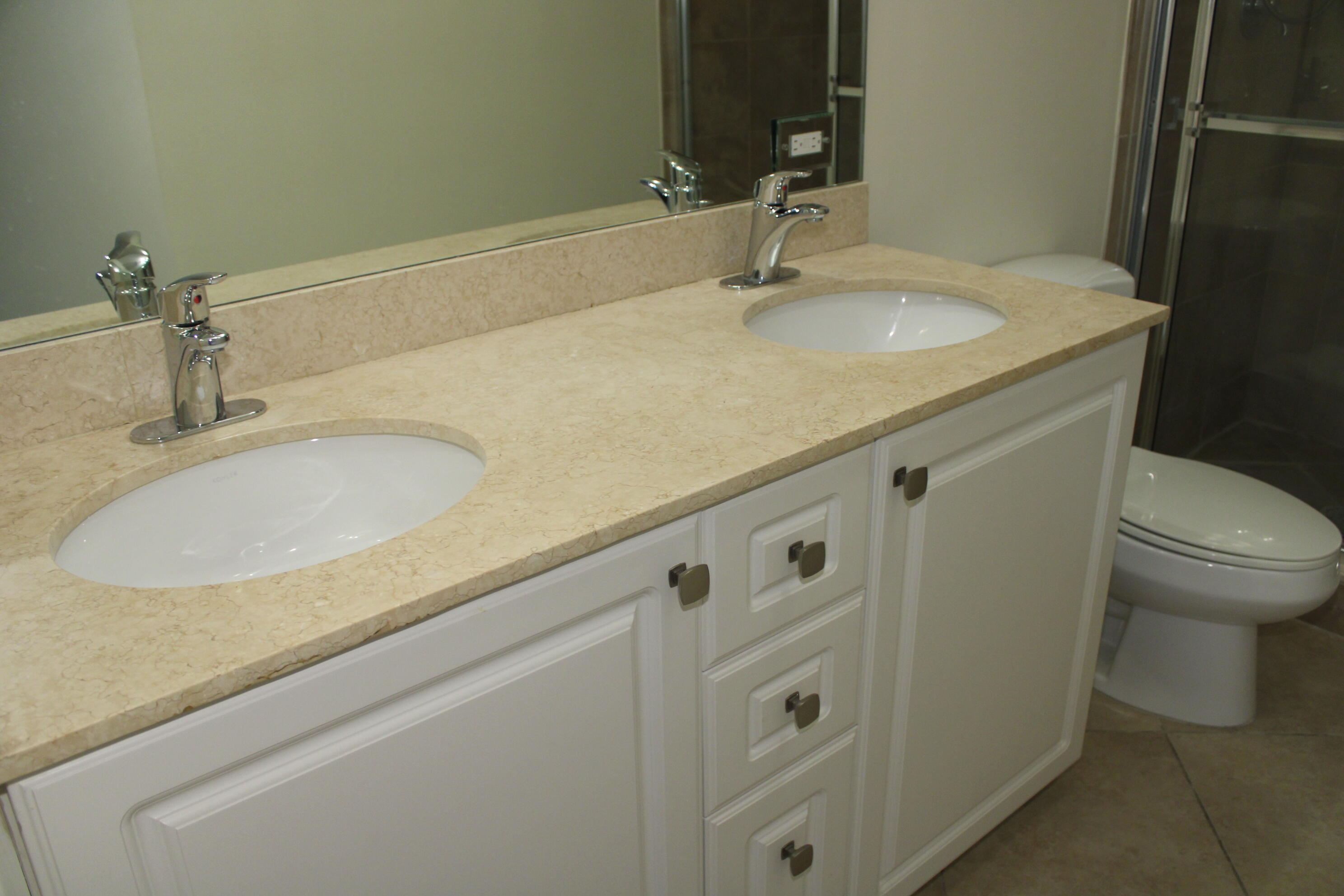 1690 Renaissance Commons Boulevard, Unit 1429 Boynton Beach, FL 33426 - Photo 21 of 23 a bathroom with a granite countertop sink and a mirror