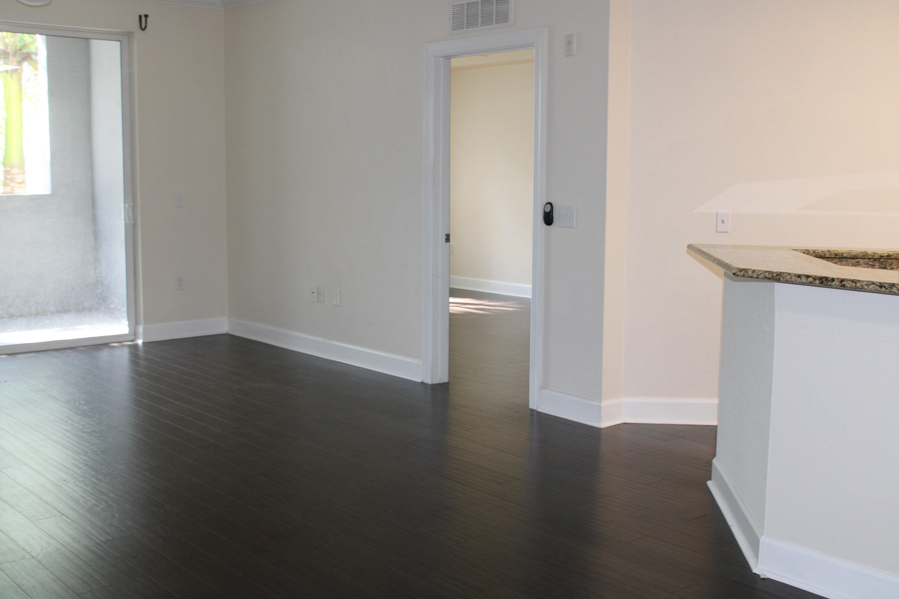 1690 Renaissance Commons Boulevard, Unit 1429 Boynton Beach, FL 33426 - Photo 4 of 23 an empty room with wooden floor and windows