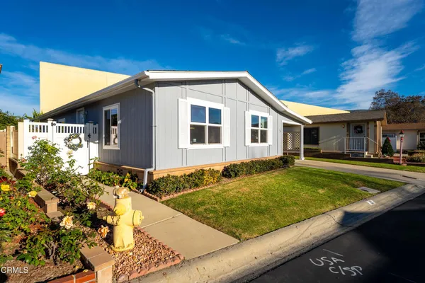 a view of a house with pool plants and a yard