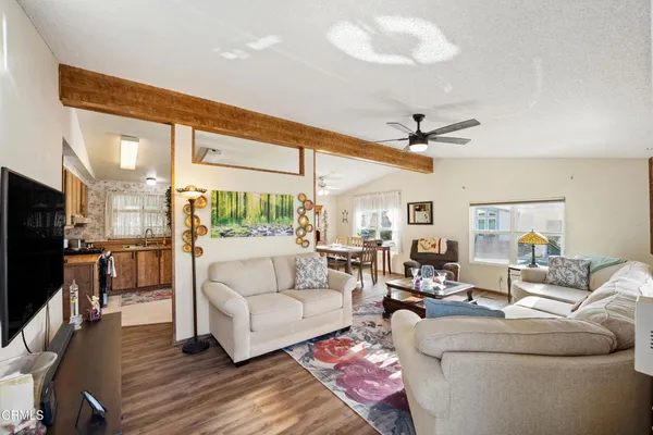 a living room with furniture a large window and a flat screen tv