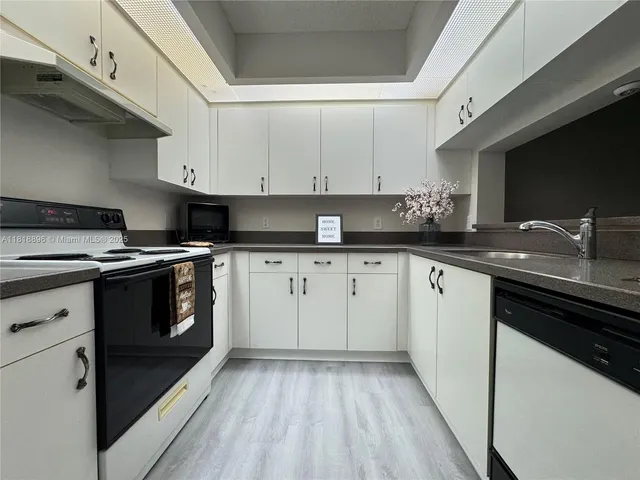 a kitchen with a sink stove and cabinets