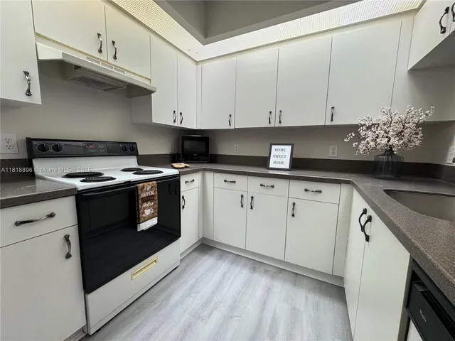 a kitchen with granite countertop white cabinets and white appliances