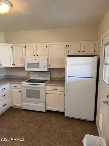 a kitchen with cabinets appliances and wooden floor