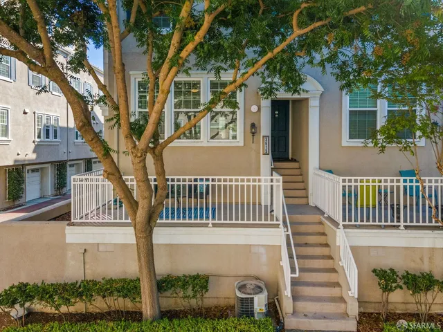 a front view of a house with a tree