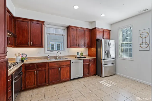 a kitchen with stainless steel appliances granite countertop a refrigerator stove top oven and sink