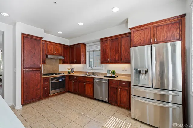 a kitchen with stainless steel appliances granite countertop a refrigerator stove top oven a sink and dishwasher
