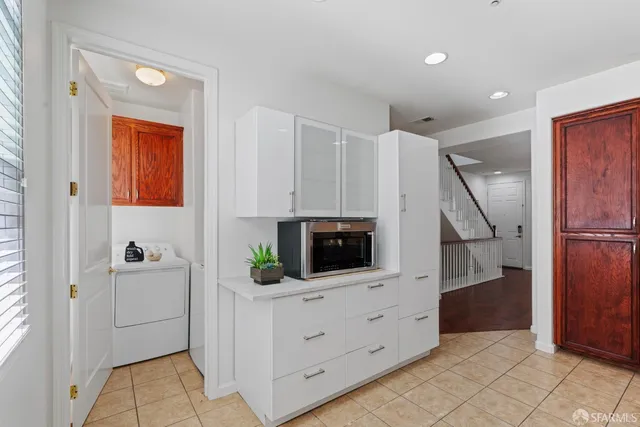 a kitchen with white cabinets and white appliances