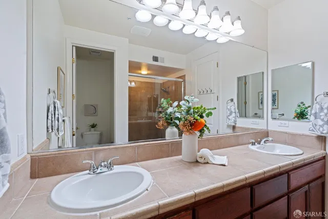 a bathroom with a granite countertop sink and a mirror