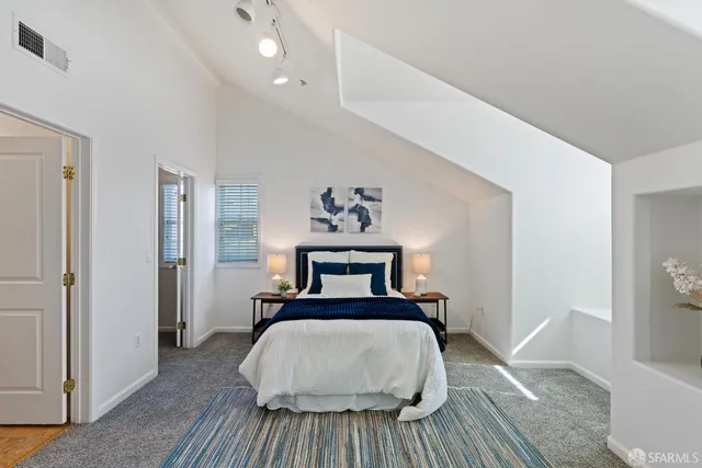 a bed room with a bed and a painting on the wall