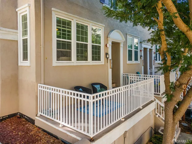 a view of a house with a small yard and wooden fence