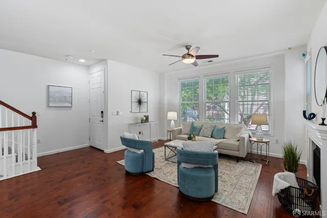 a living room with furniture large window and wooden floor